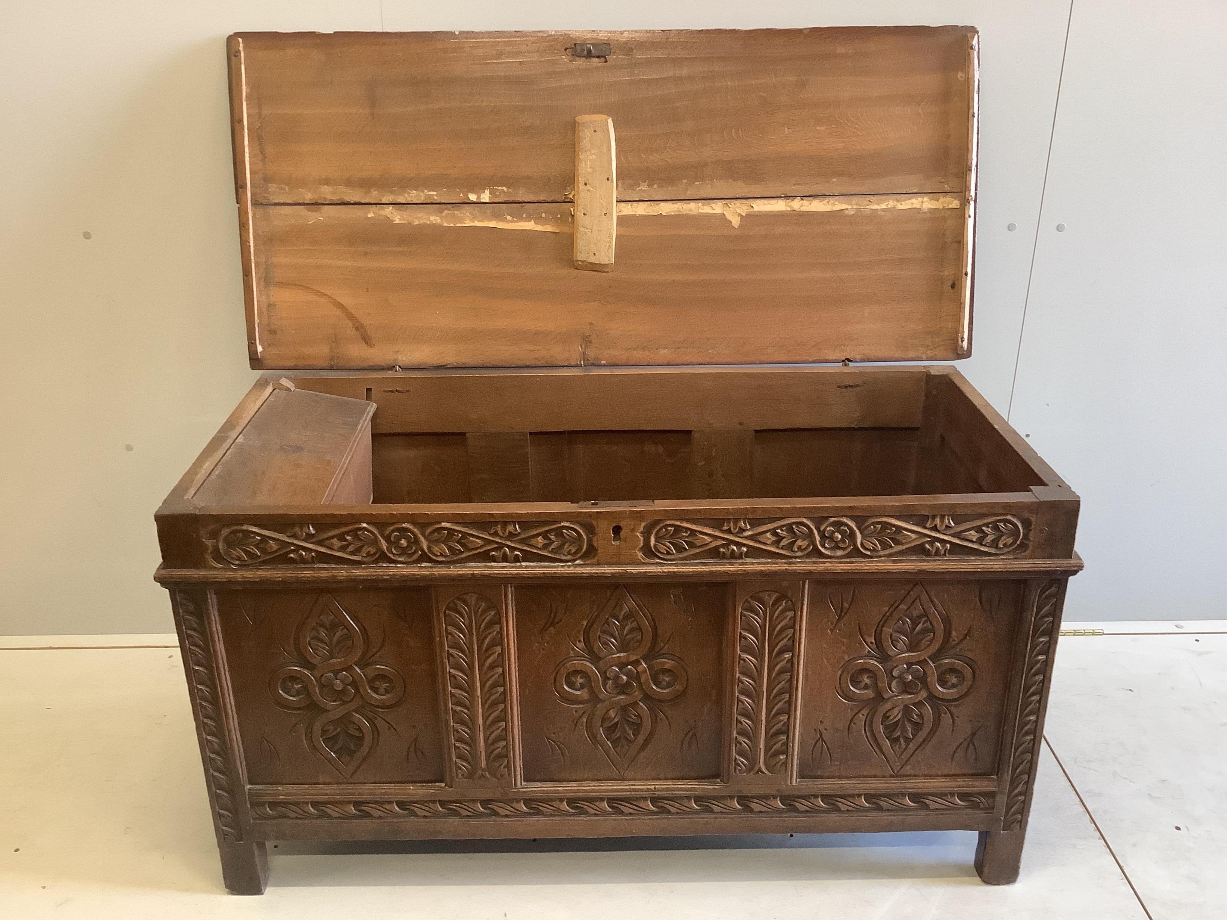 An early 18th century carved oak coffer with two plank top, width 133cm, depth 59cm, height 70cm